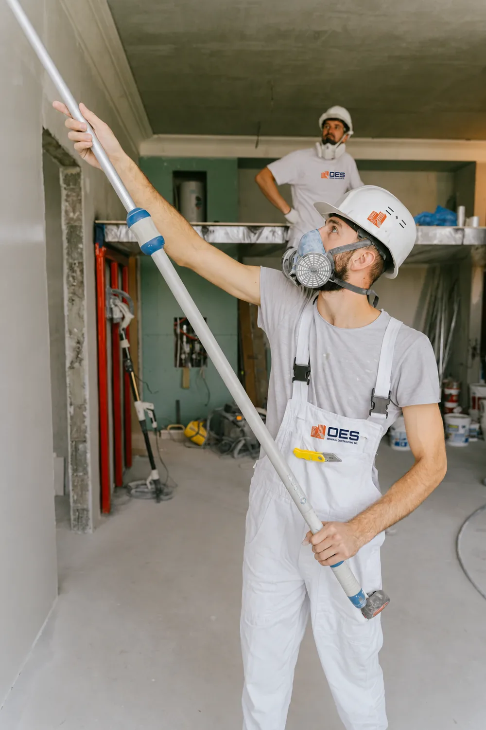 Painter in a respirator working on a room being renovated