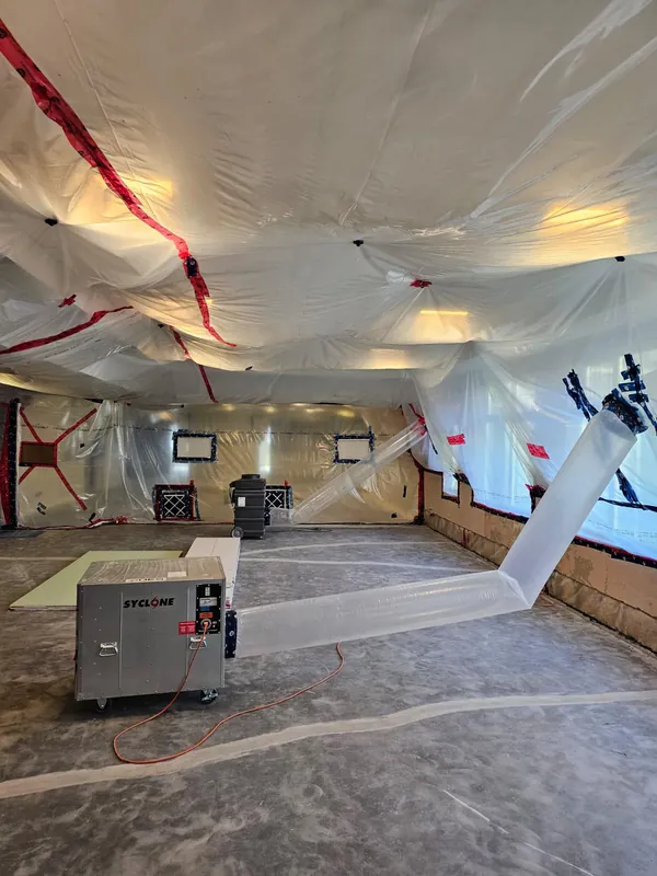 Lounge sealed in plastic containment with an air scrubber during remediation