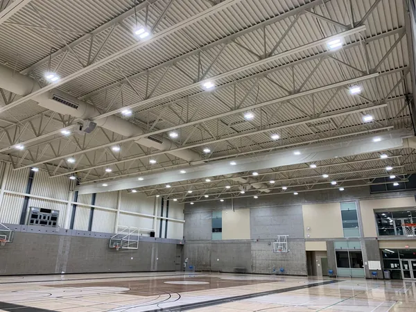 Gymnasium at the Christine Sinclair Community Centre with exposed trusses and lighting