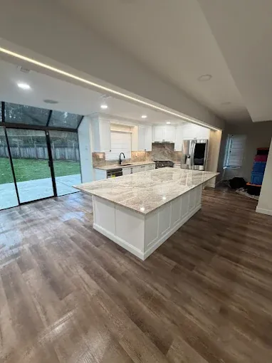Open kitchen with a stone-topped island and large windows