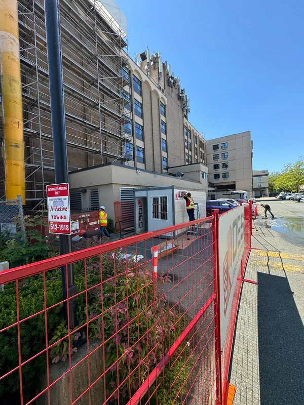 Scaffolded building with an OES site office and red site fencing
