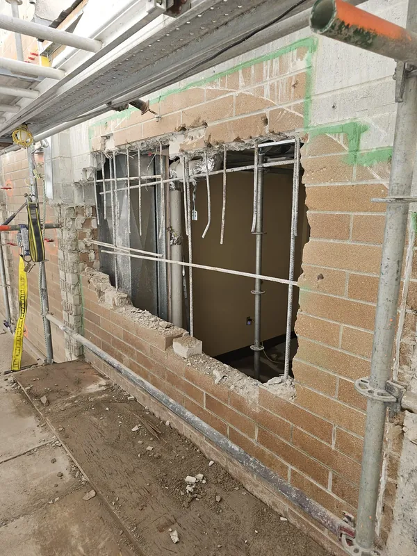 Brick wall opened to the new rebar, under scaffolding