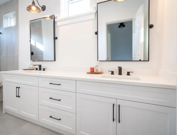 Bathroom with a white double vanity and black framed mirrors