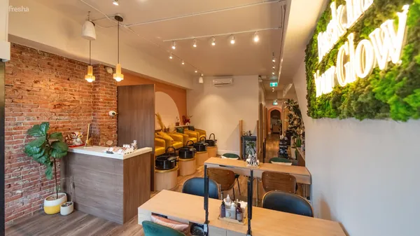 Salon interior with a brick wall, pedicure chairs and a moss wall