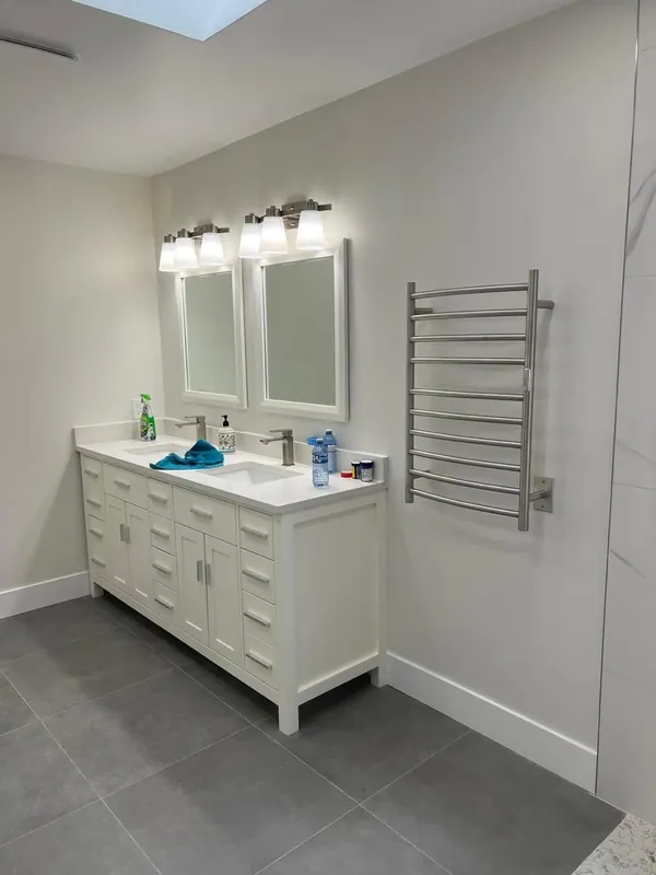 Bathroom with a white double vanity and a heated towel rail