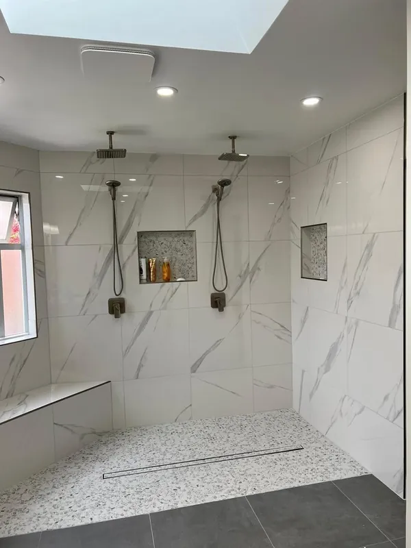 Walk-in shower with two shower heads and wall niches