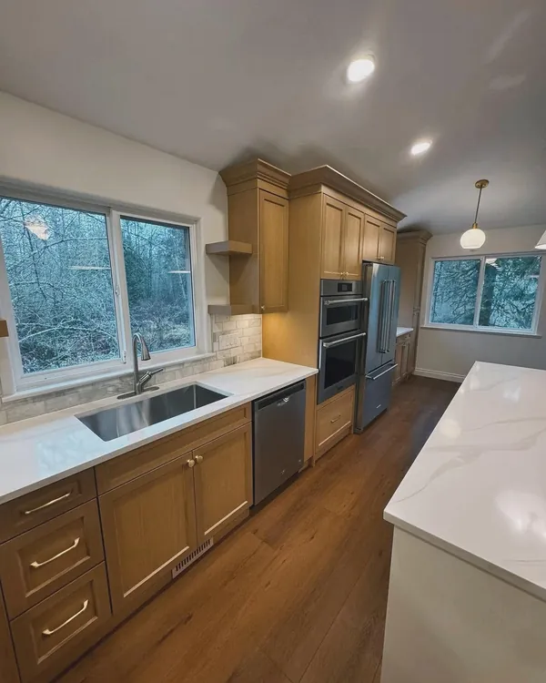 Kitchen sink under a window with a tile backsplash